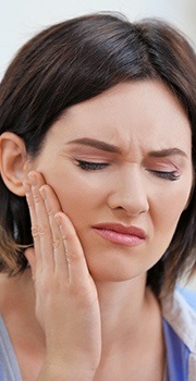 Woman holding cheek in pain