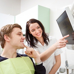 man pointing to smile while member points to x-ray